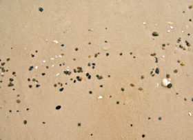 Small pebbles and stones in the beach sand