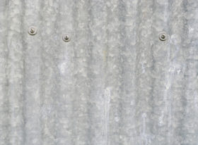 old corrugated iron metal background with screws