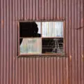 old rusty tin (corrugated iron) metal shed with window