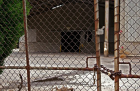 photo of an old factory all closed down and the gate is locked