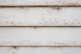 close photo of a wooden weatherboard white wood panels background