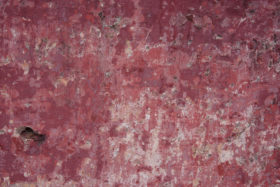 old worn red concrete temple wall