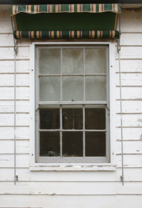 Background images of two different windows in white weatherboard walls