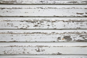 White wood wall with peeling paint and closeup texture