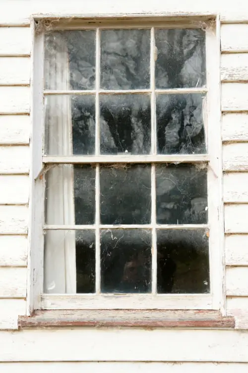 old window in wooden weatherboard wall