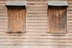 boarded up windows in a wooden wall