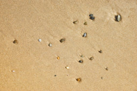 Three photos of small stones and beach sand