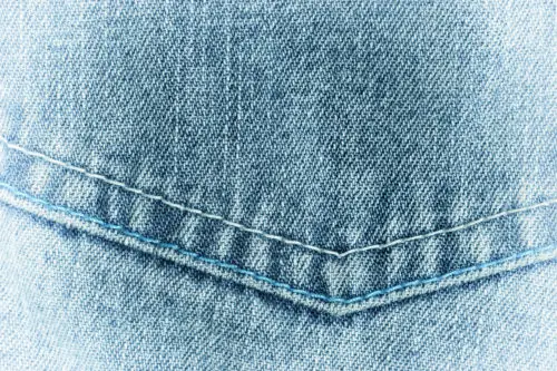 photo of the pocket of old faded denim jeans image