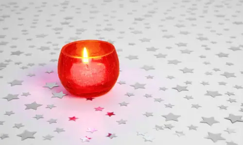 red candle with silver stars on white