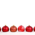 row of christmas balls on white