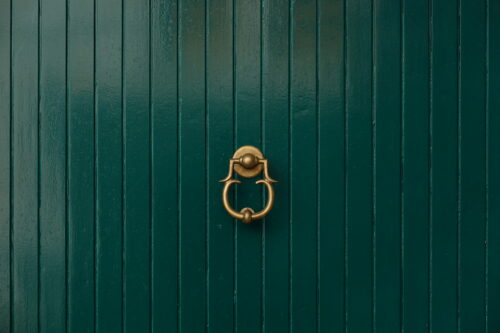 Green door with golden door knocker free stock photo. Landscape orientation.