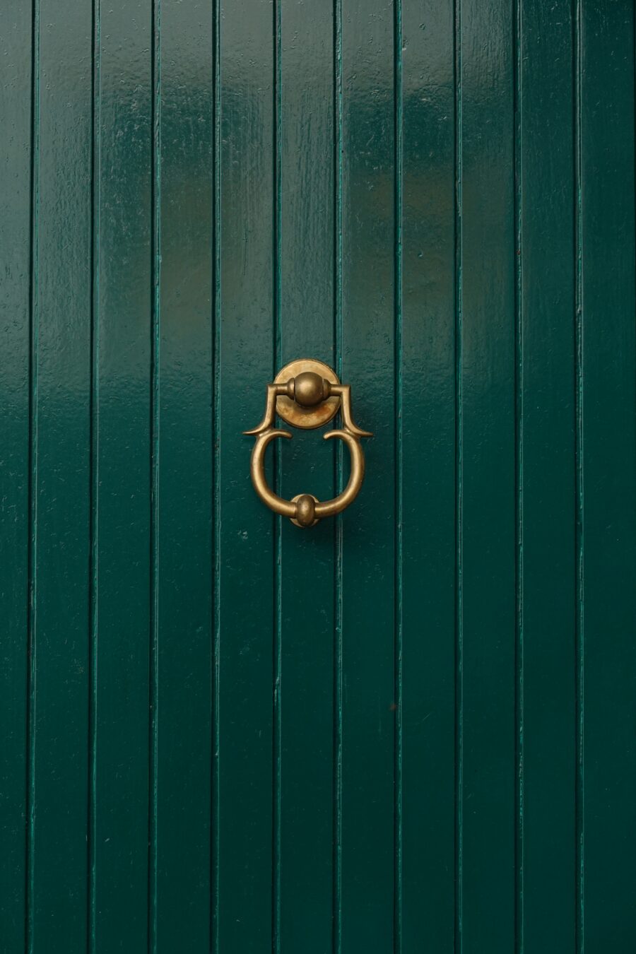 Green door with golden door knocker free stock photo. Portrait orientation.